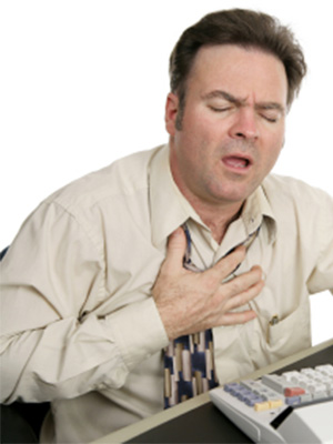 Man sitting at a desk having a heart attack.